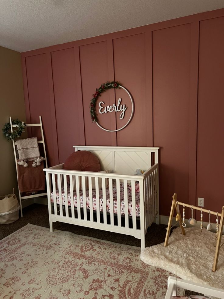 a baby's room with a crib, rocking chair and wall hangings