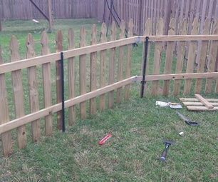 a wooden fence in the middle of a yard