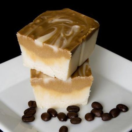 two pieces of cake sitting on top of a white plate with coffee beans around it