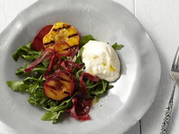 a white plate topped with salad next to a fork