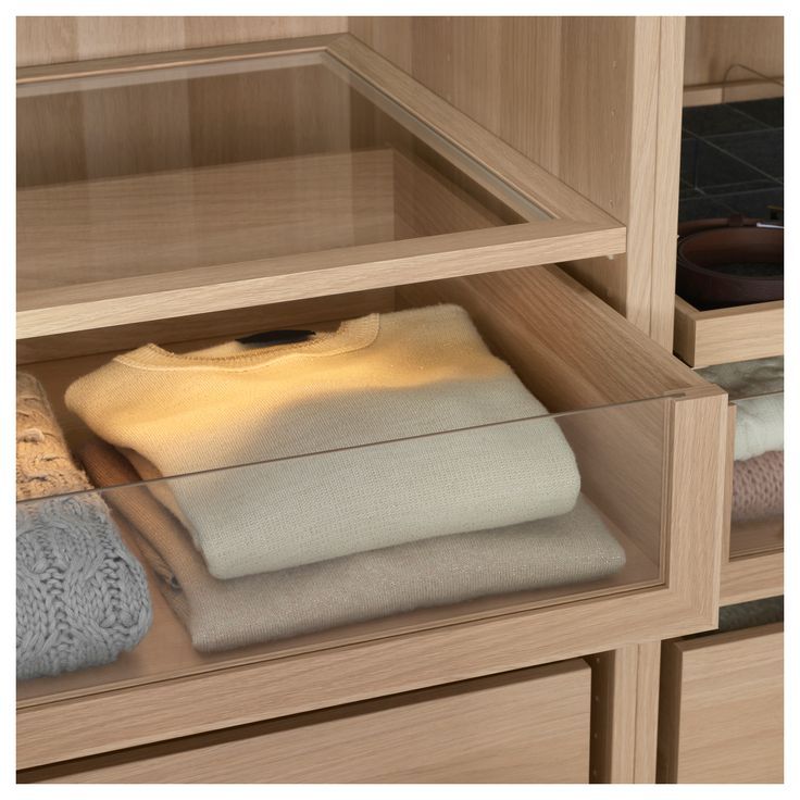 an image of a closet with folded clothes on it's shelves and the bottom shelf is open