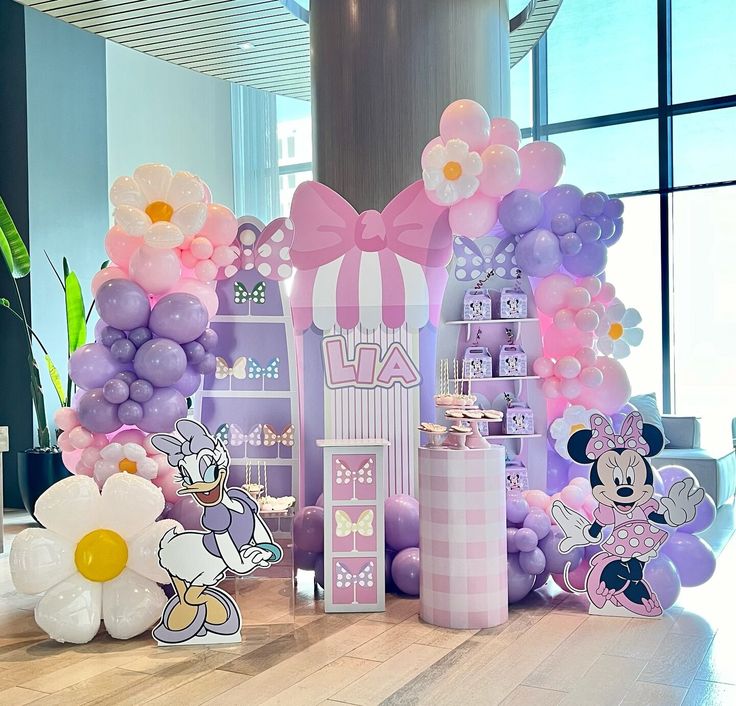 balloons and decorations are on the floor in front of a wall with minnie mouses