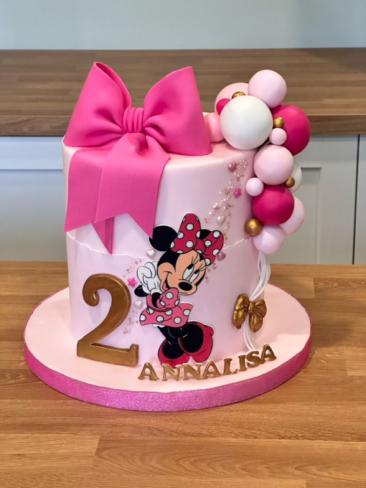 a minnie mouse birthday cake with balloons on the top and number 2 on the bottom