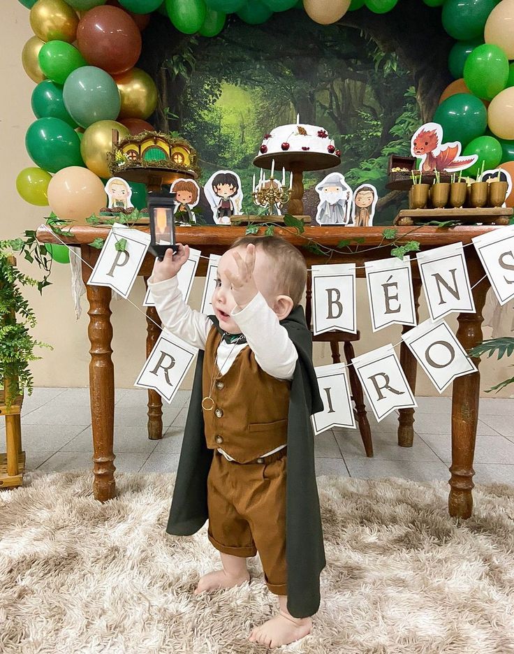 a little boy that is standing in front of a table with some decorations on it