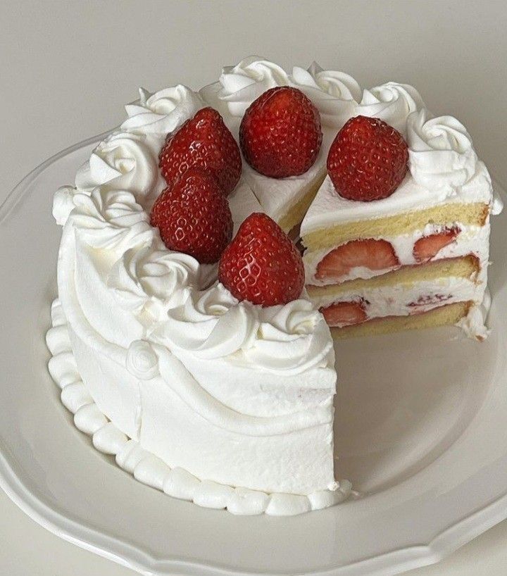 a cake with white frosting and strawberries on top