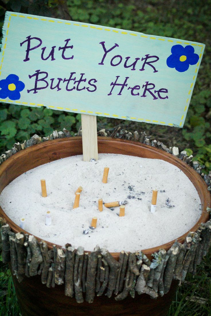 a sign that says put your butts here on top of a potted plant