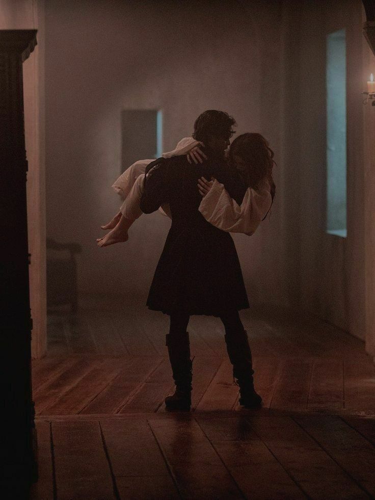 black and white photograph of a man holding a woman in an old - fashioned room