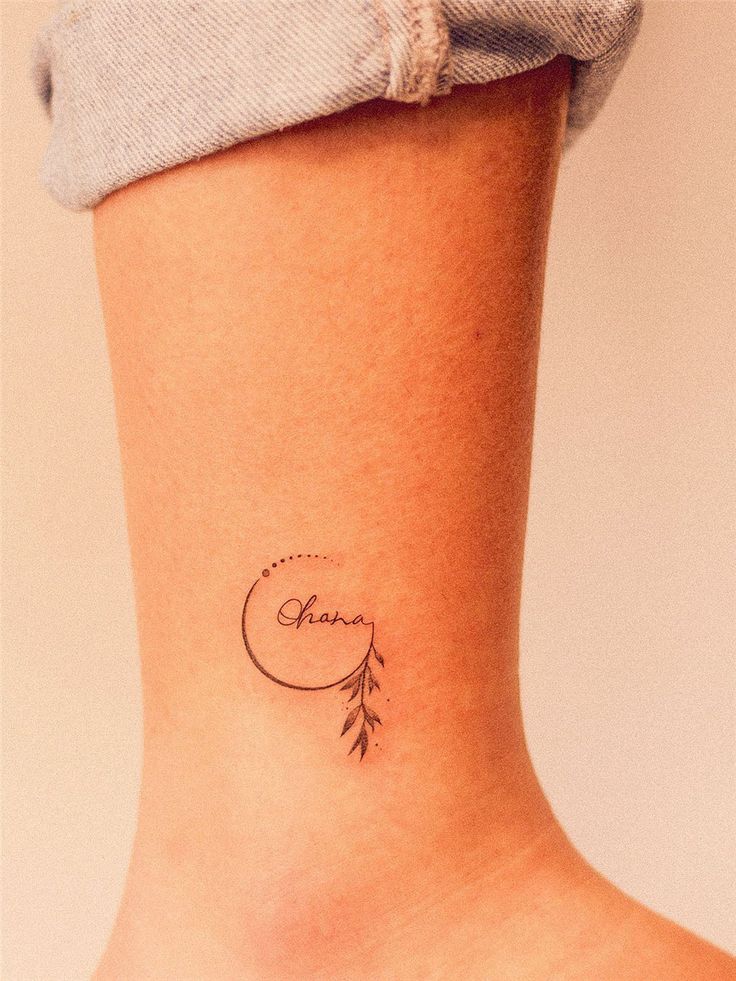 a woman with a small tattoo on her ankle that reads,'enjoy'and an arrow