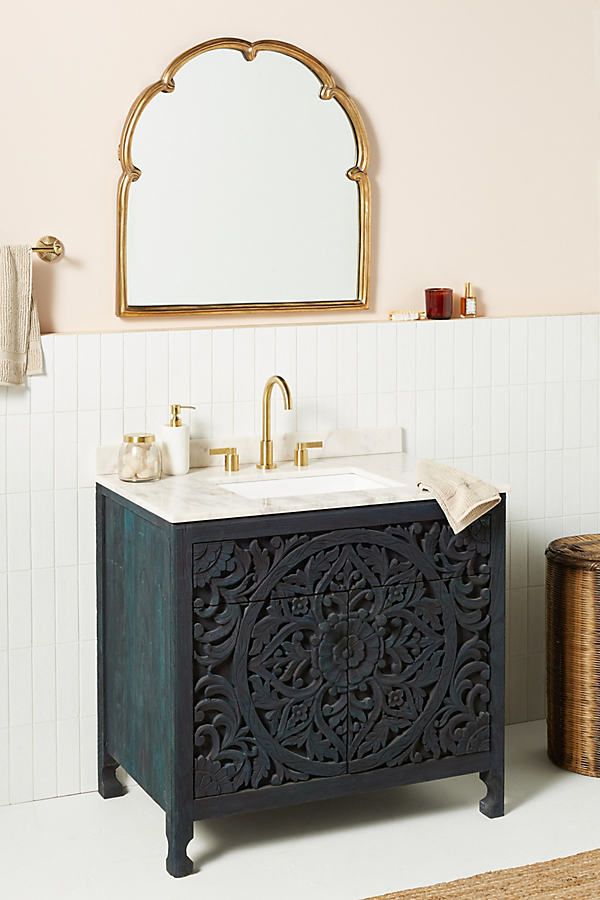 a bathroom with a sink and mirror next to a rug on the floor in front of it