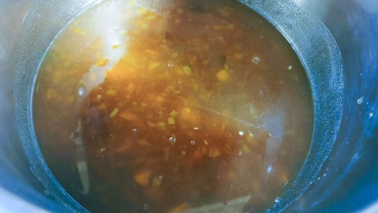 a metal pot filled with soup on top of a table