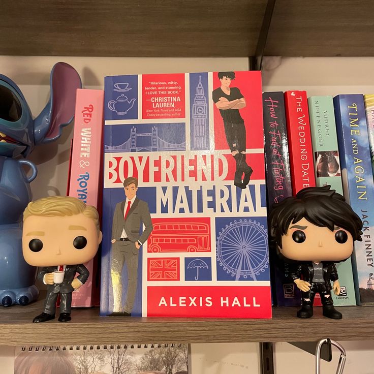 some books and figurines are sitting on a book shelf next to each other