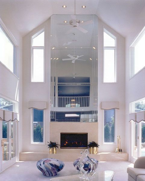 a large living room with high ceilings and white furniture