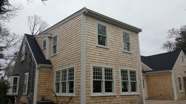 a two story house with white windows and brown siding