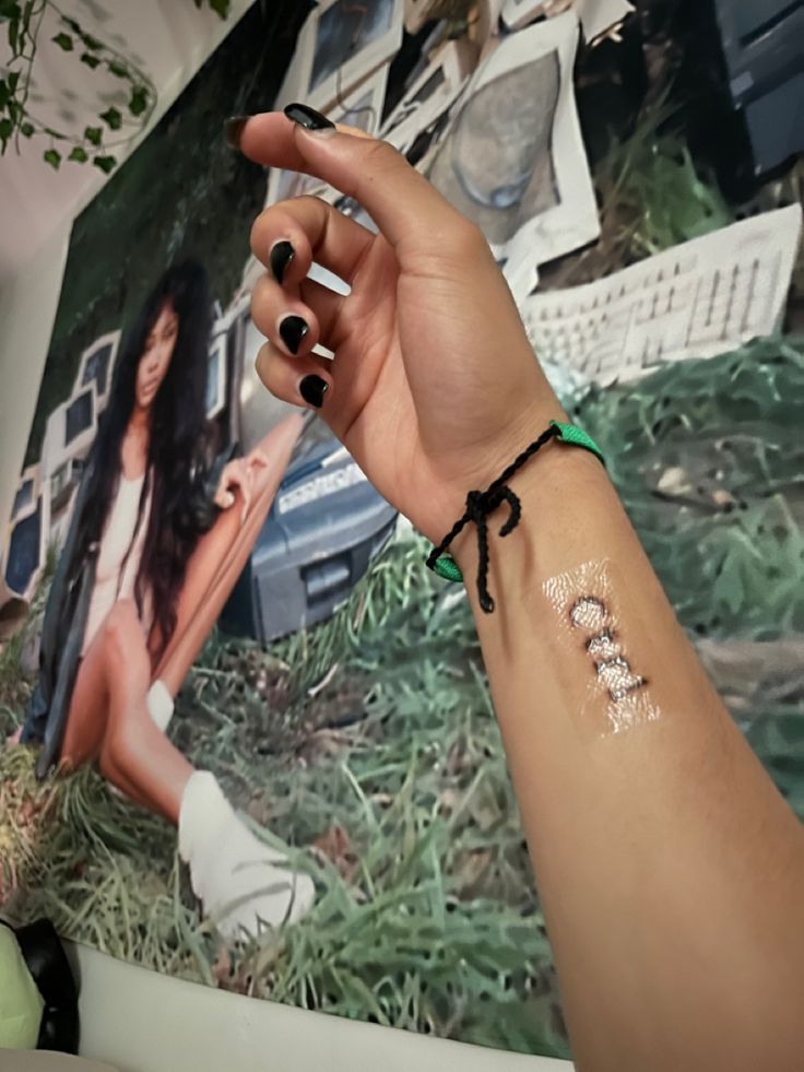 a woman's arm with a small tattoo on her left wrist and the word love written in white ink