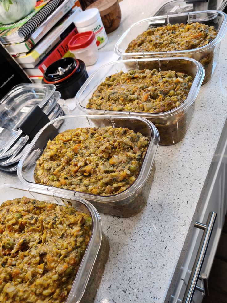 four plastic containers filled with food sitting on top of a counter