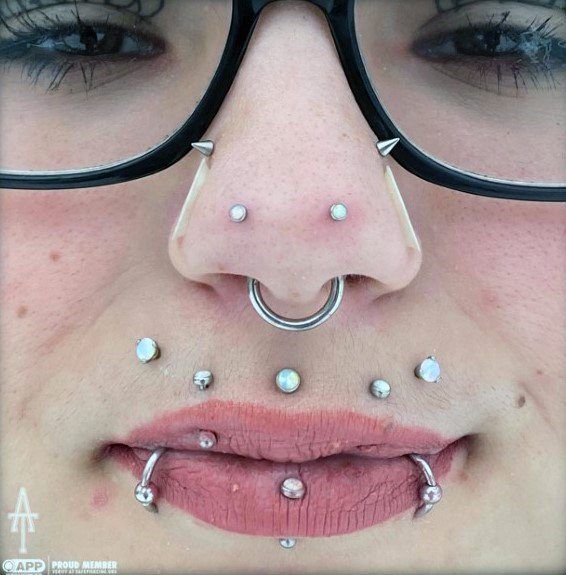 a woman with piercings on her nose and nose ring in front of her face