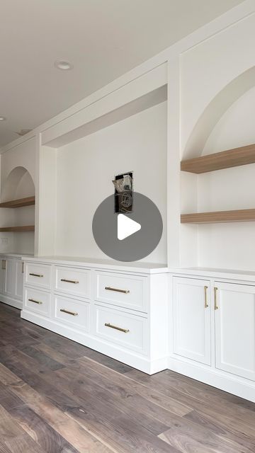 an empty room with white cabinets and wood flooring is shown in the foreground