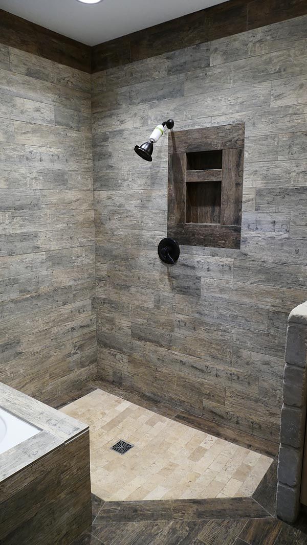 a bathroom with a toilet, sink and shower stall in it's corner area