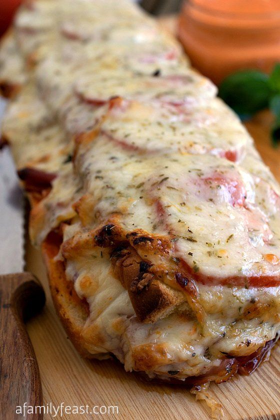 a cheesy pizza on a wooden cutting board