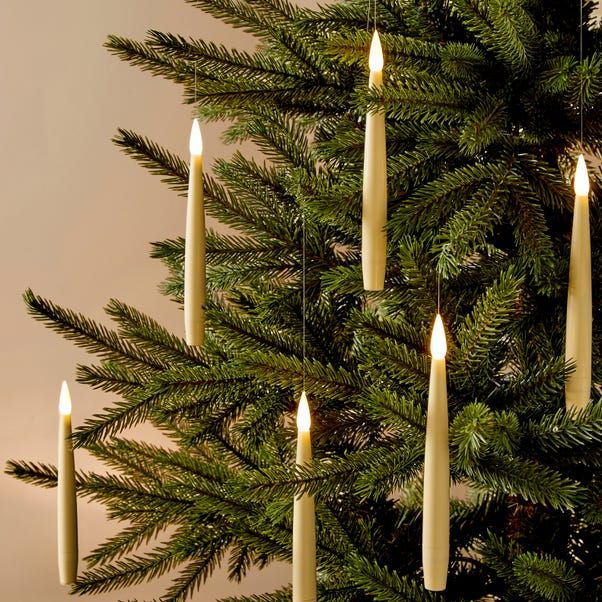 a christmas tree with lit candles hanging from it