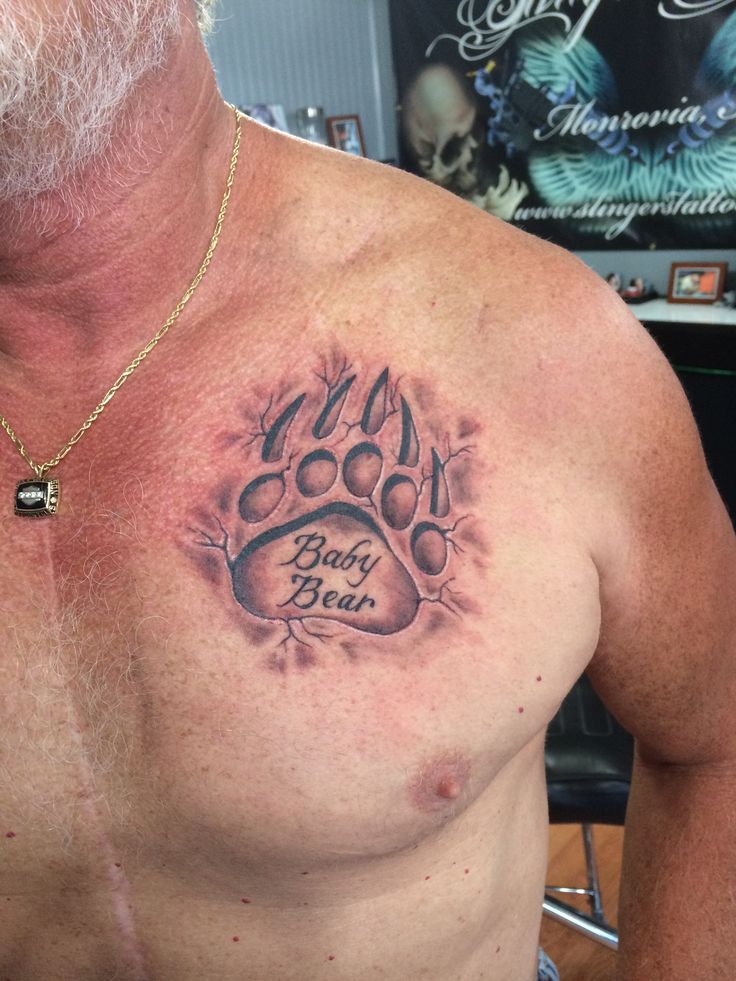 a man with a dog paw tattoo on his chest