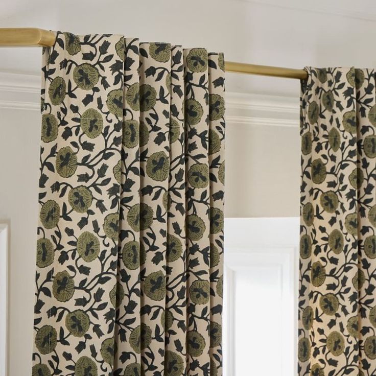 the curtains in this room are decorated with black and green flowers