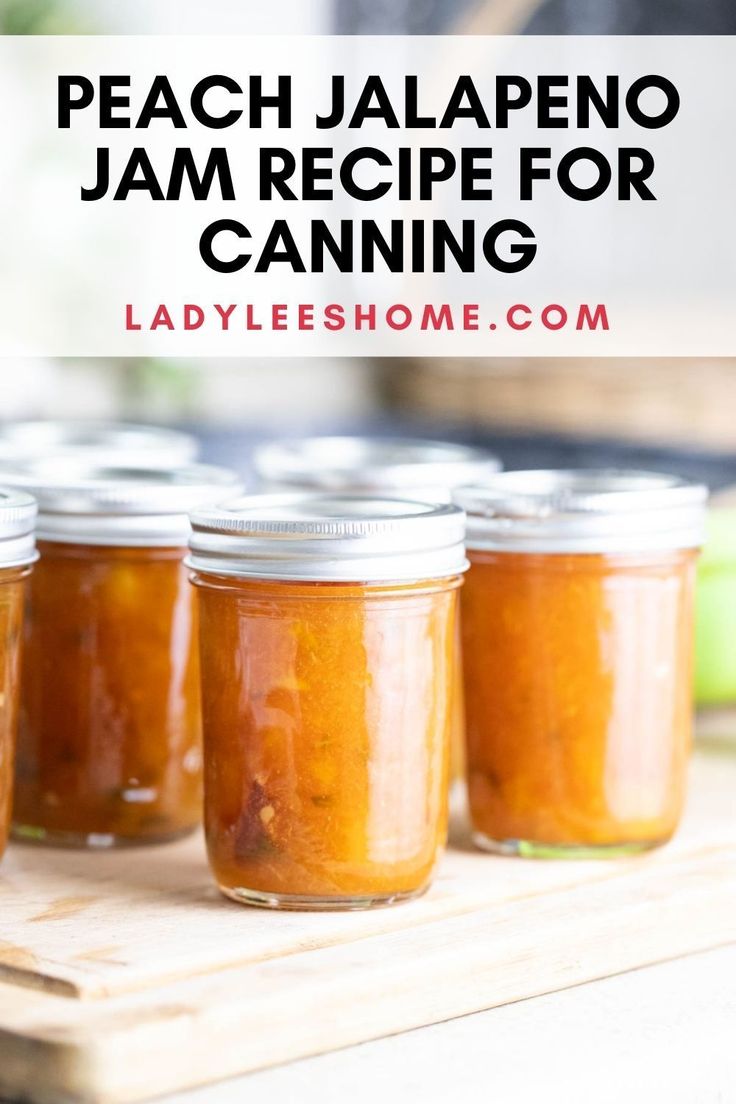 four jars filled with peach jalapeno jam sitting on top of a cutting board