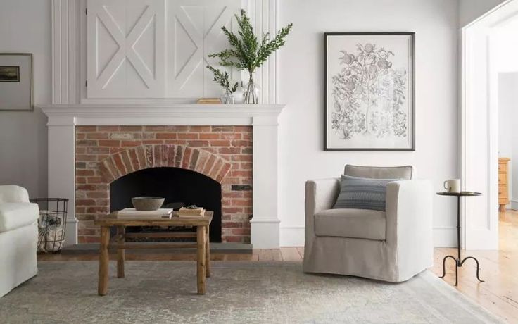 a living room filled with furniture and a fire place in front of a brick fireplace