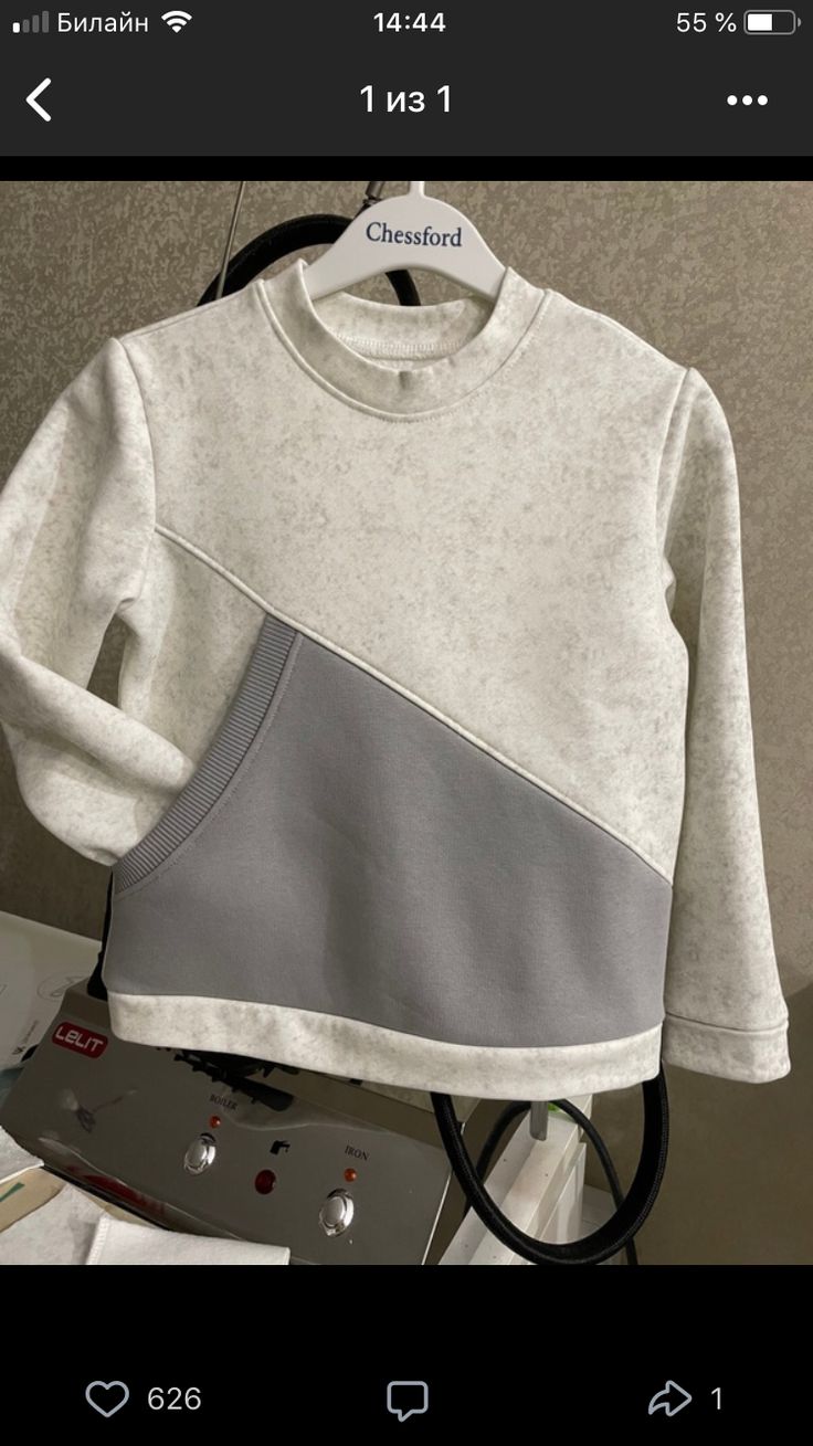 a white and grey sweater with black trim