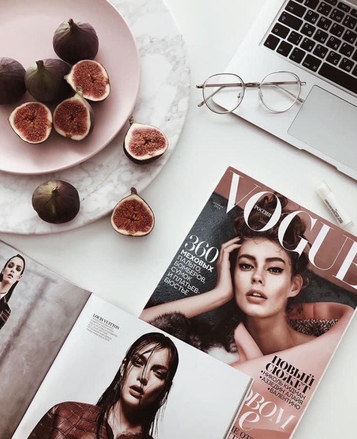 an open magazine sitting on top of a table next to a plate with figs