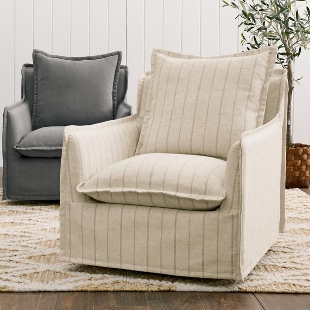 two chairs sitting next to each other on top of a rug in front of a white wall