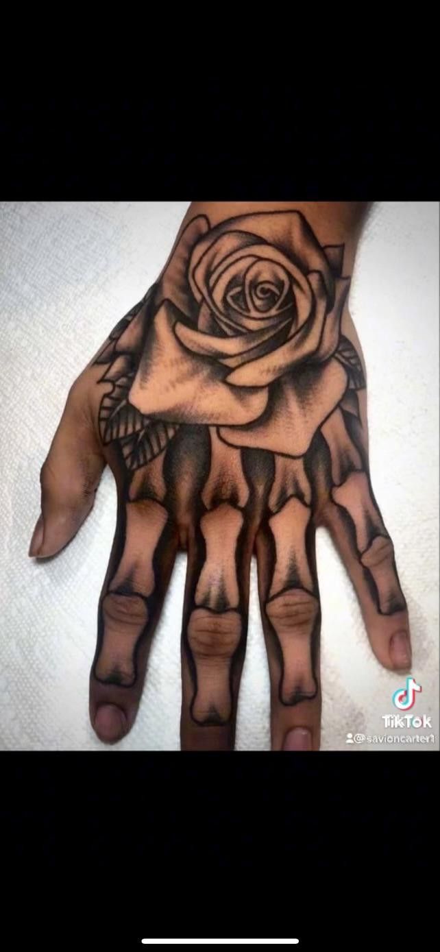 a hand with a rose tattoo on it