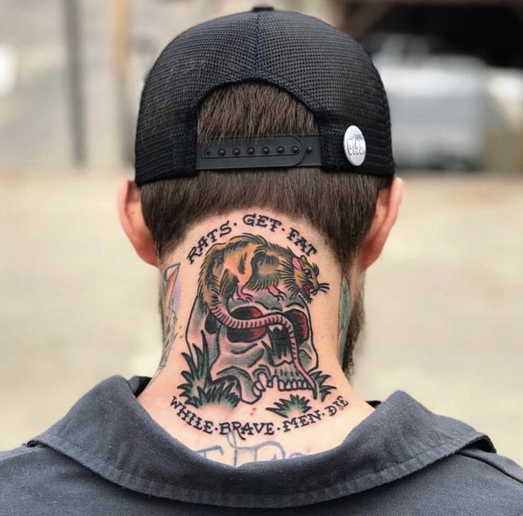 the back of a man's head with tattoos on his neck and behind him is an image of a tiger