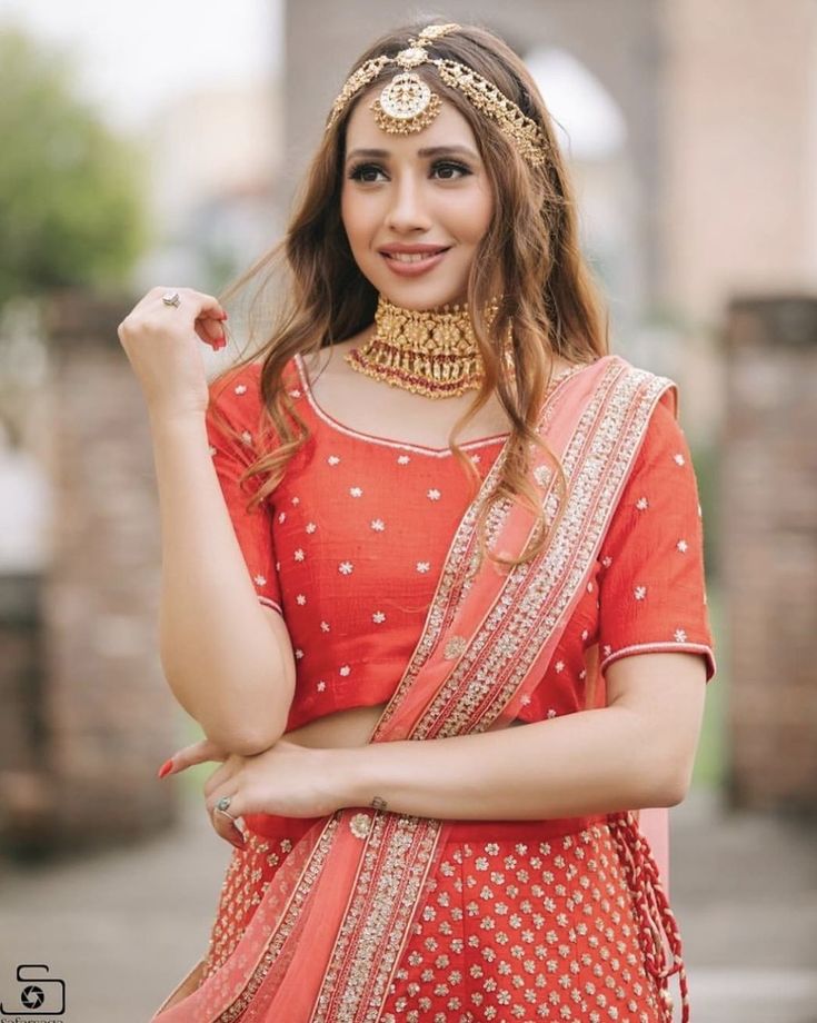 a woman in an orange outfit posing for the camera with her hands on her hips