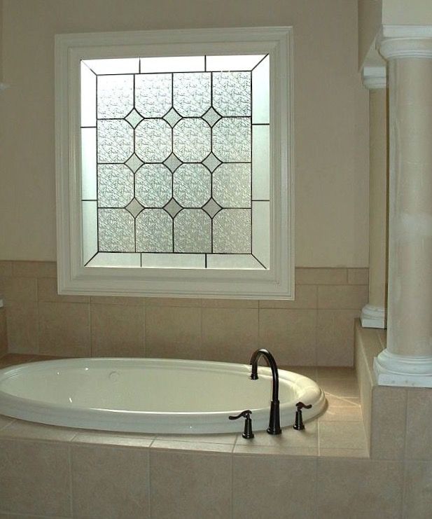 a bath tub sitting under a window in a bathroom