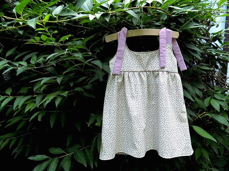 Cute little dress with color-coordinated straps that tie. Makes putting it on and taking it off quick and easy. The soft cotton fabric is comfortable to wear and just right for a hot summer day. The top of the dress is lined with purple fabric, matching the straps. The dress has a heart button closure at the back. Dimensions: Length (without straps): 37 cm Strap: approx. 27 cm Chest circumference: 55 cm Cotton Suspender Dress For Spring Vacation, Summer Cotton Sundress With Adjustable Straps, Cotton Sundress With Adjustable Straps For Summer, Summer Cotton Suspender Dress With Adjustable Straps, Cotton Suspender Dress For Summer Vacation, Cotton Sleeveless Suspender Dress For Vacation, Summer Sleeveless Cotton Suspender Dress, Cotton Suspender Dress With Adjustable Straps For Summer, Playful Sleeveless Dress With Tie Straps