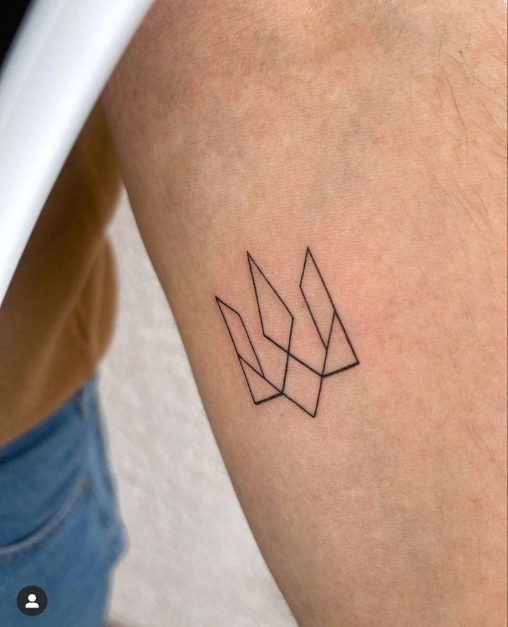 a woman's arm with a small geometric tattoo on the back of her leg