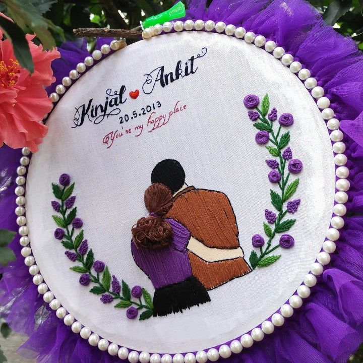 an embroidered wedding ornament with the bride and groom hugging