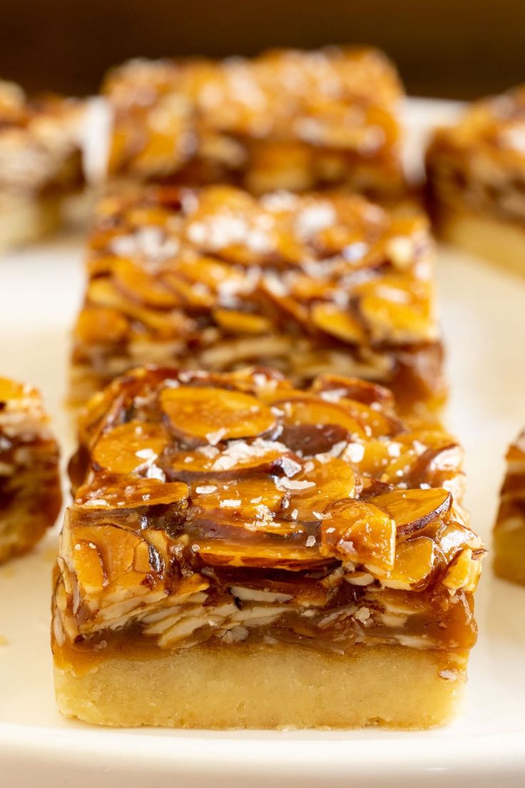 several pieces of dessert sitting on top of a white plate with caramel toppings