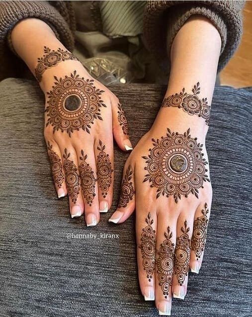 a woman's hands with henna tattoos on them