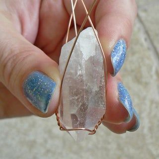 a person holding a piece of jewelry with blue and white speckles on it