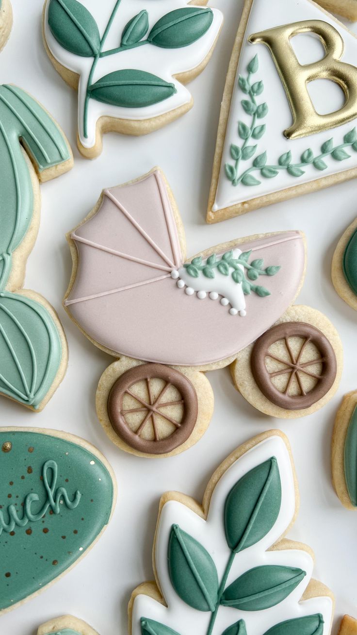 decorated cookies are arranged in the shape of baby's stroller, buggy, and leaves