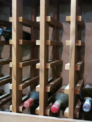 several bottles of wine are lined up in a wooden crate with wood slats on the sides