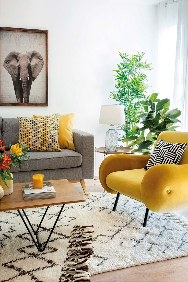 a living room filled with furniture and a painting on the wall above it's coffee table