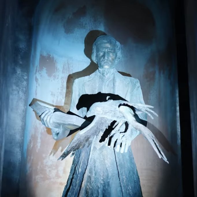 an image of a statue that appears to be holding something in his hands and wearing gloves