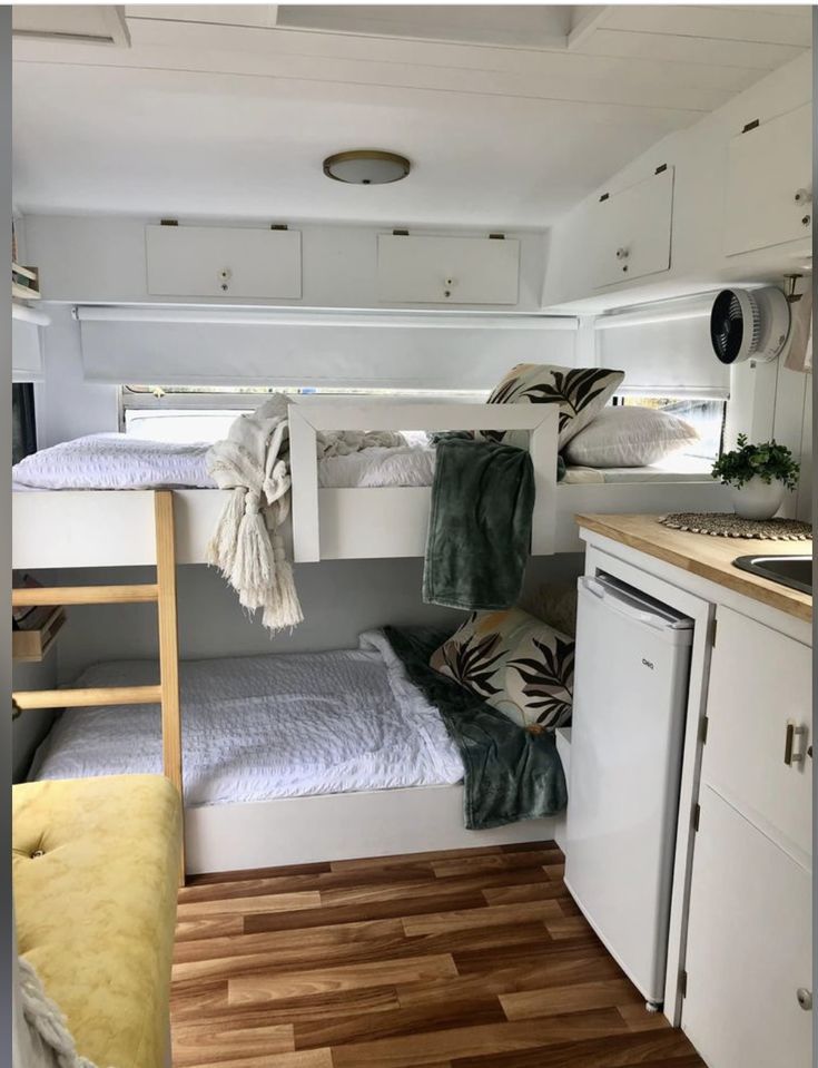 there is a bunk bed in the middle of this small room with wood flooring