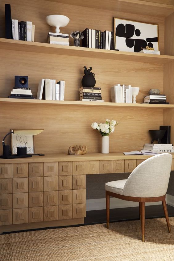 a chair and desk in a room with bookshelves on the wall behind it