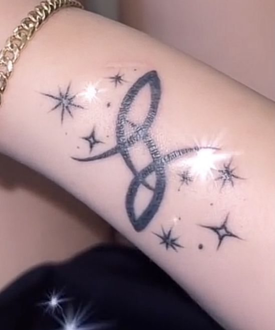 a woman's arm with a tattoo on it that has stars and an infinite symbol