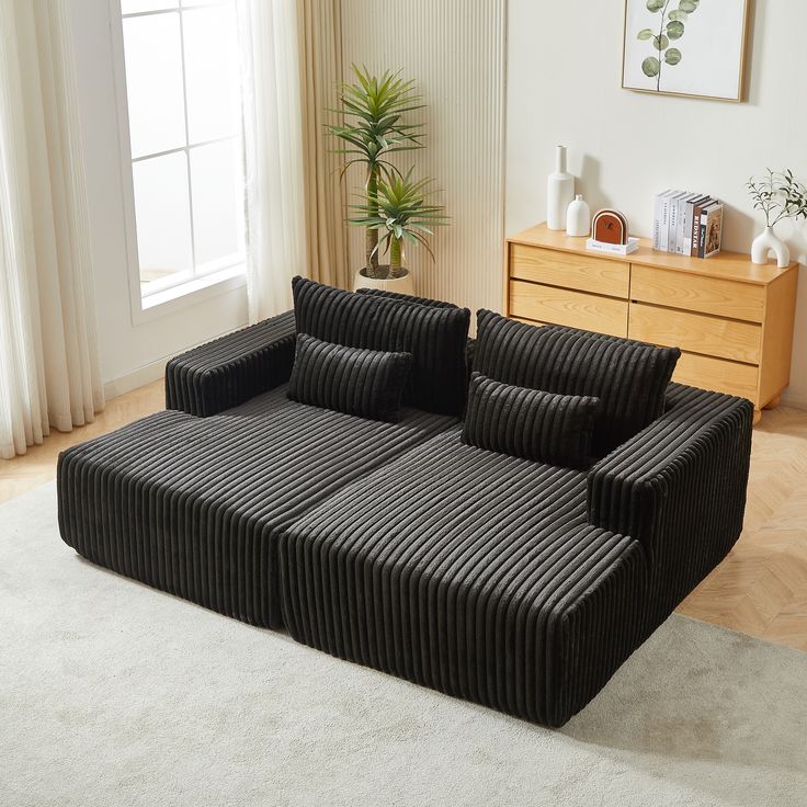 a black and white striped couch sitting on top of a rug in a living room