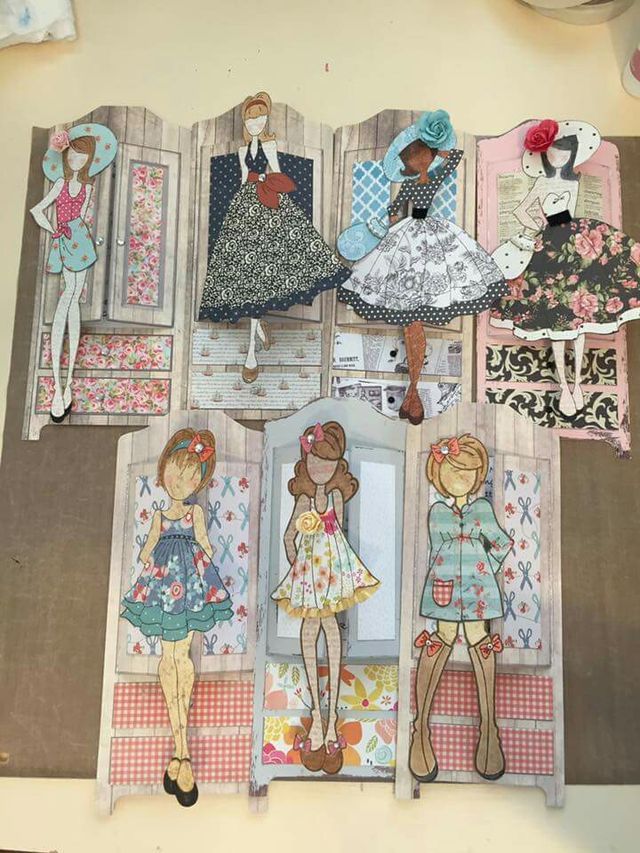 an open book with cut outs of girls in clothes